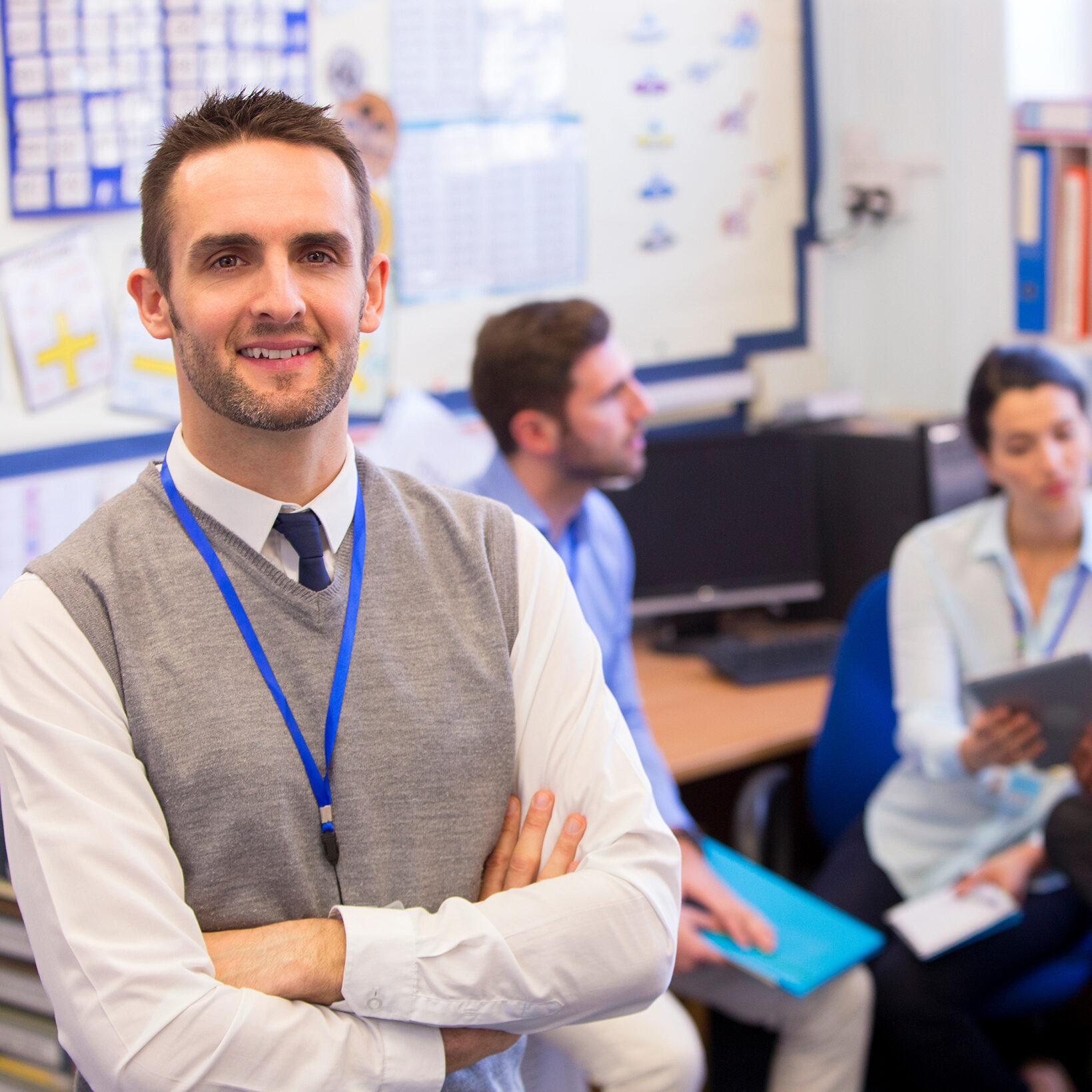 teacher-with-badge confident male teacher wearing badge on lanyard with badge